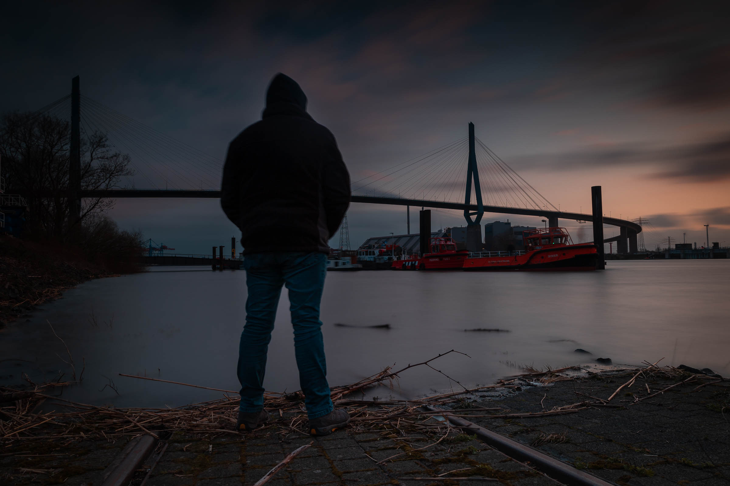 Dieses Bild zeigt einen Menschen im Dunkeln vor der Köhlbrandtbrücke